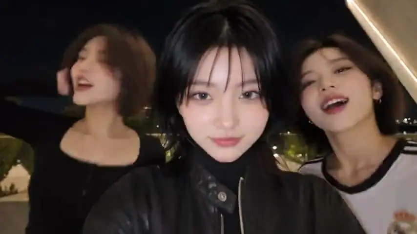 Three performers together at night, with the lead in a black jacket closest to the camera.