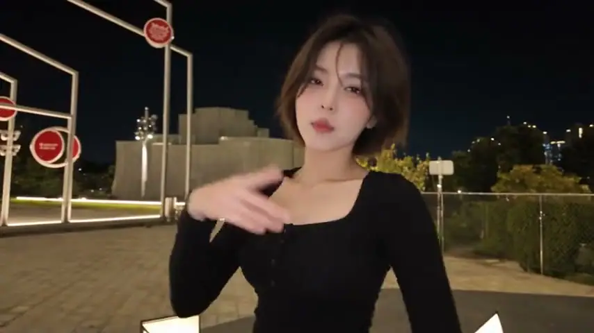 The performer in a black top making hand gestures during an individual shot.